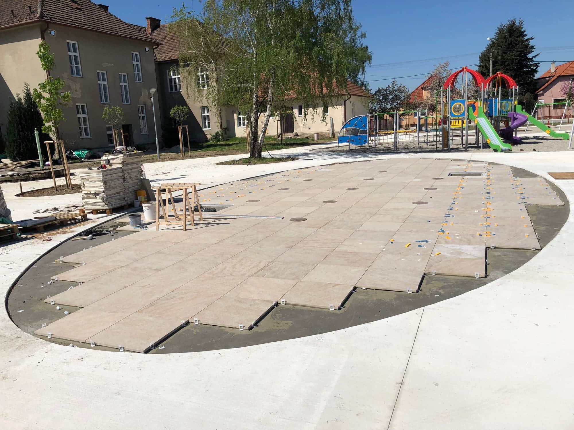 Kladenie veľkoformátovej dlažby na kruhovej ploche počas realizácie